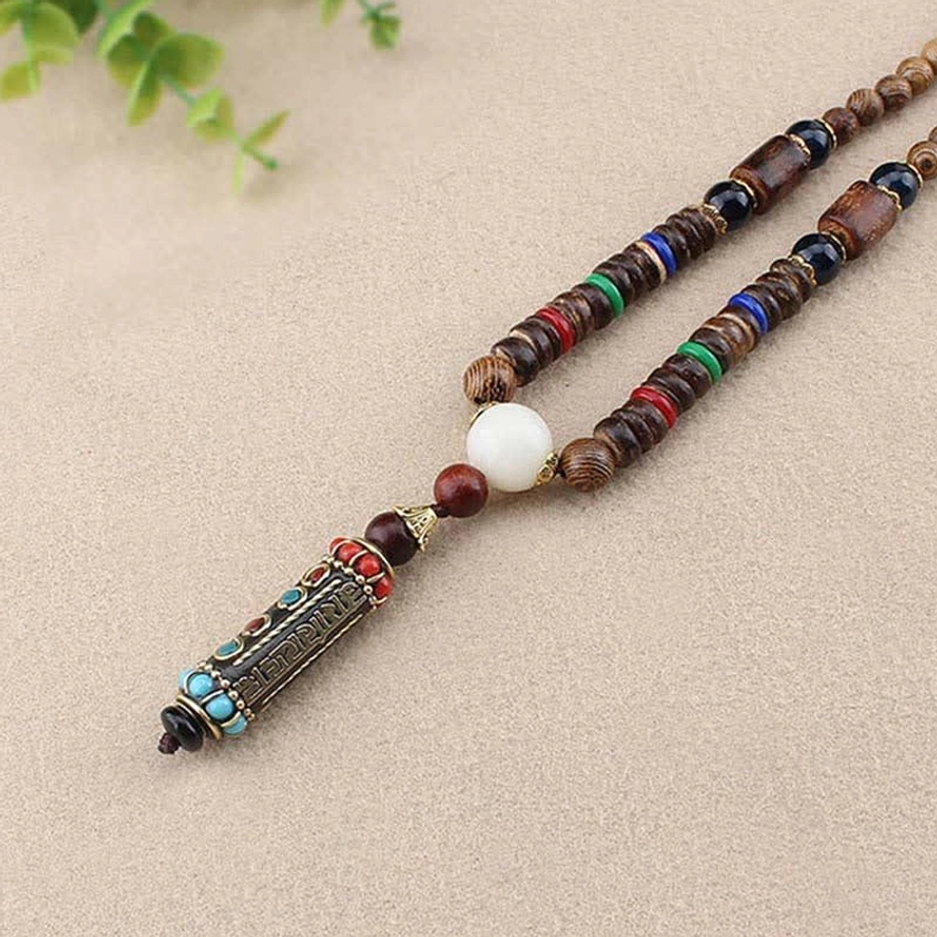 Wenge wood bead chain necklace with sacred mantra pendant and green foliage, natural materials detail