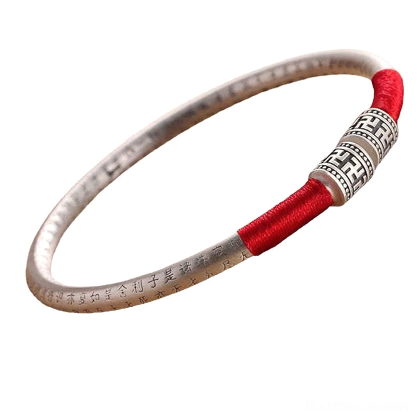 Om Mani Padme Hum silver scripture bangle with red silk wrap, side angle view showing engraved text detail