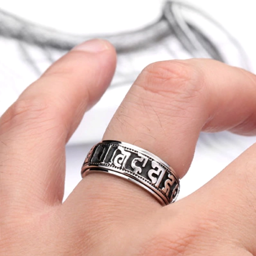 Om Mani Padme Hum spinner ring worn on finger, close-up showing rotatable band design