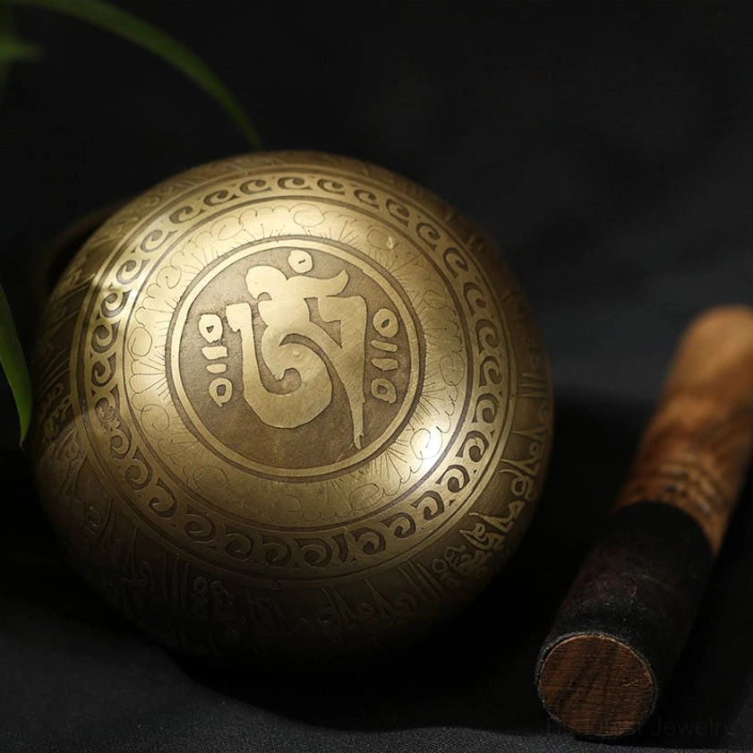 Buddhist singing bowl with Om symbol engraving and sacred decorative border patterns