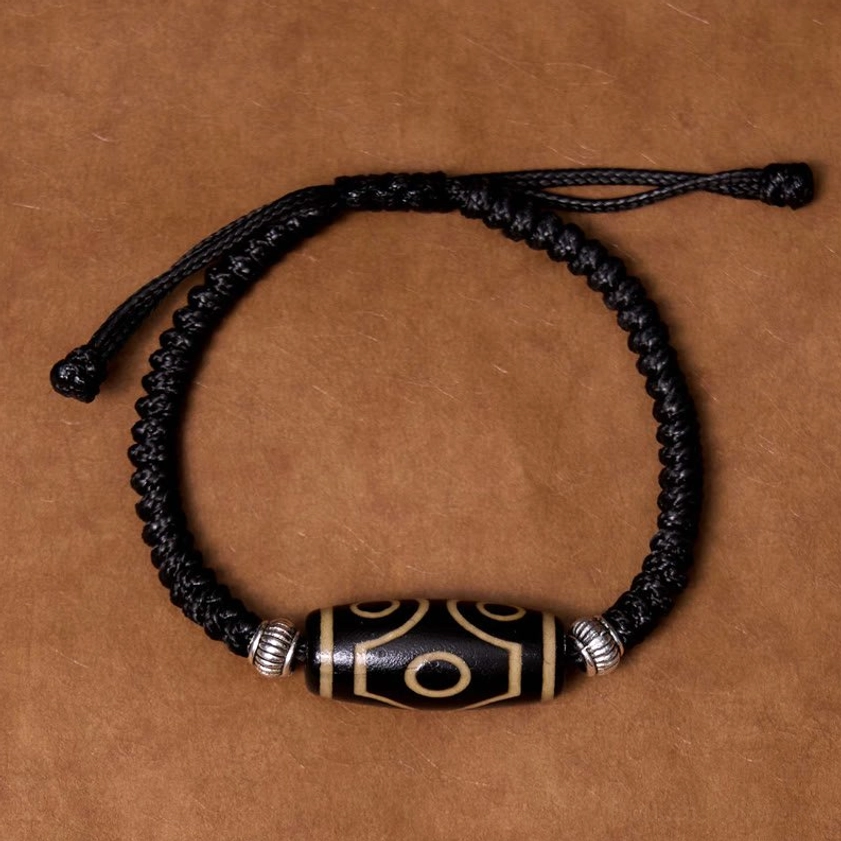 One-eye dzi bead bracelet overhead view showing single sacred eye pattern on natural stone bead