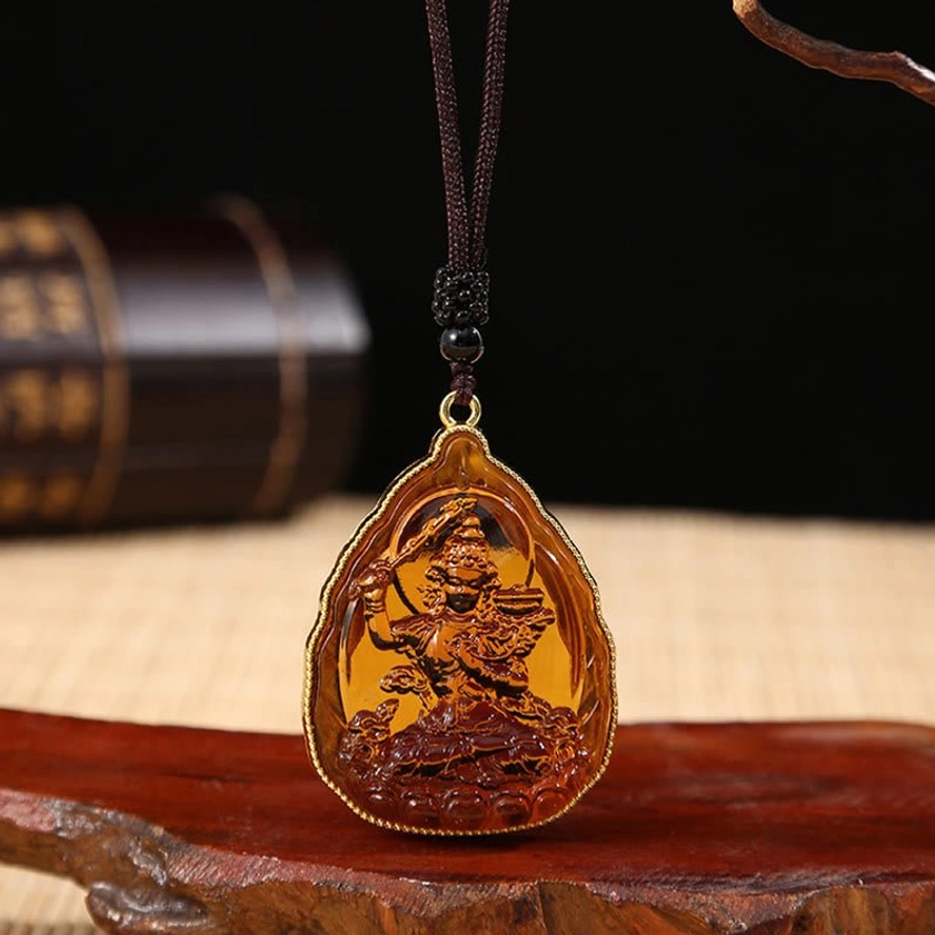 Orange Buddhist Buddha crystal pendant necklace with vibrant orange Liuli crystal, embossed Buddha design and gold metal frame on black beaded cord