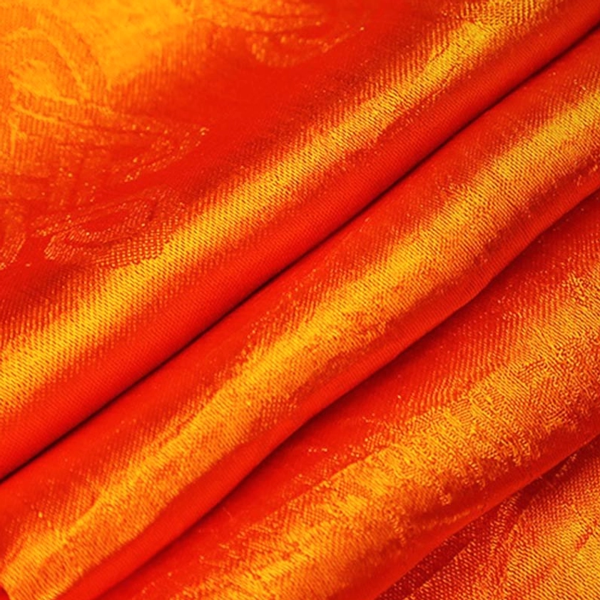 Orange Buddhist blessing khata scarf close-up showing smooth shiny satin finish with warm gradient tone