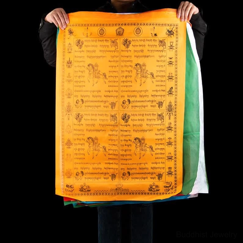 Orange Buddhist windhorse prayer flag held by hands showing detailed windhorse and scripture printing