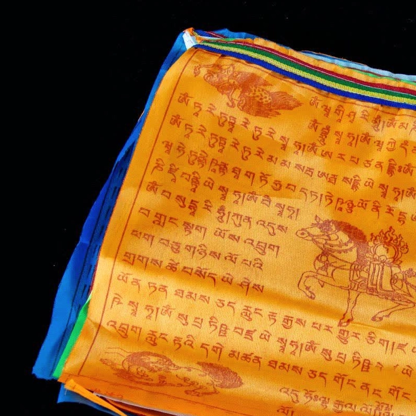 Individual large orange prayer flag with printed windhorse and Tibetan Buddhist scriptures and colorful border trim