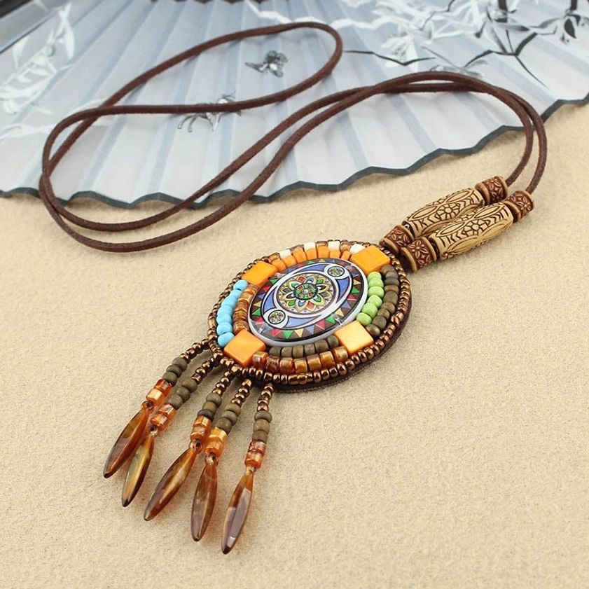 Oval mandala beaded pendant necklace with blue and orange mosaic design and mixed seed beads