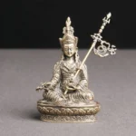 Padmasambhava Buddha handcrafted copper statue with lotus pedestal and ritual staff, frontal view on grey background