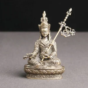 Padmasambhava Buddha handcrafted copper statue with lotus pedestal and ritual staff, frontal view on grey background