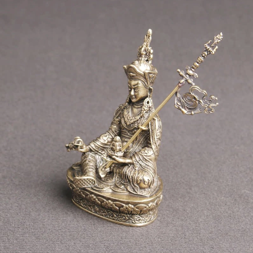 Padmasambhava Buddha statue three-quarter view showing ritual khatvanga staff and lotus pedestal base