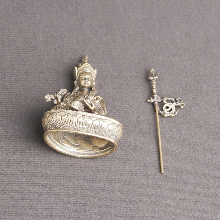 Padmasambhava Buddha statue disassembled flat lay showing separated body, ritual staff, and hollow lotus base