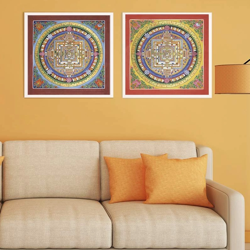 Two matching Kalachakra Mandala Thangka paintings with red borders displayed symmetrically above beige sofa in modern interior