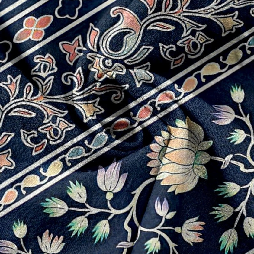 Vintage paisley and lotus stripe texture on navy blue women's harem pants fabric closeup