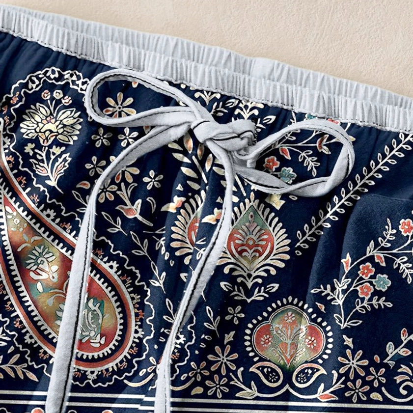 Close-up of navy paisley harem pants elastic waist with light gray drawstring and trim detail