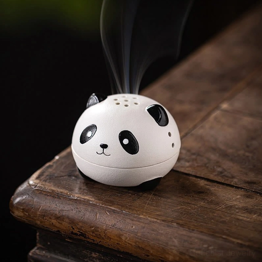 Low three-quarter view of handcrafted panda incense burner on vintage wooden shelf, two-piece ceramic body emitting smoke