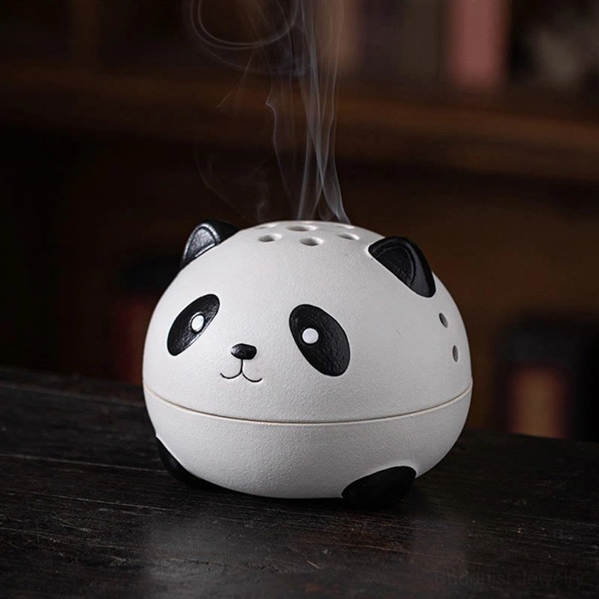 Front close-up of handcrafted panda incense holder on dark wooden desk, perforated smoke lid with black-and-white matte finish and incense burning