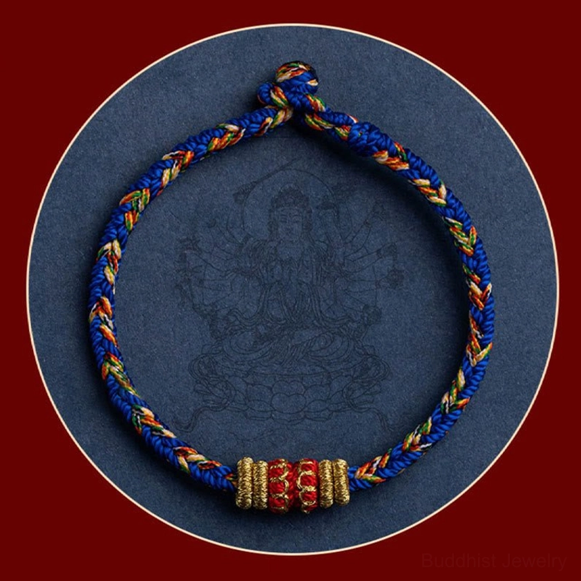 Zodiac natal buddha bracelet with blue braided rope on red background with faint buddha pattern