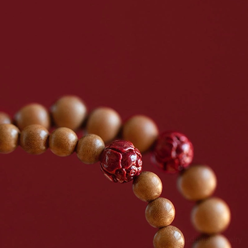 Macro close-up of peach wood beads and carved cinnabar lotus accents, showing craftsmanship details and natural texture