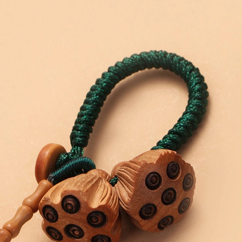 Spiritual Buddhist keychain with dual lotus pods and green braided rope for protection and luck