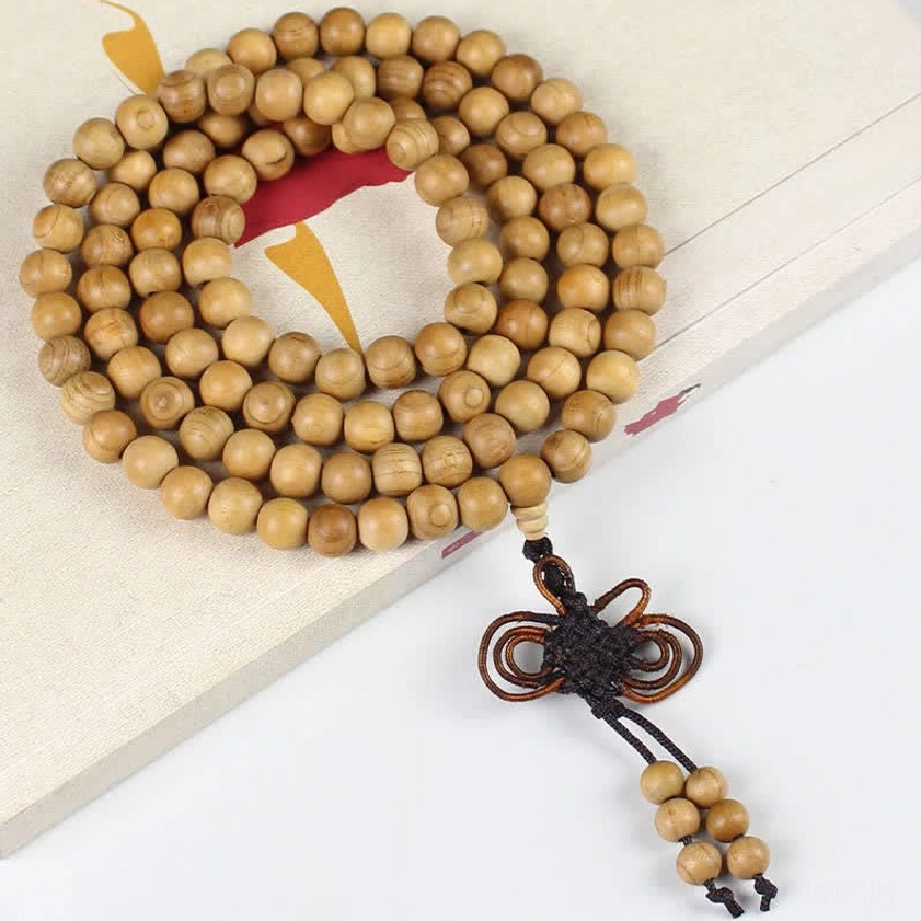 10mm peach wood Buddhist mala with ornate Chinese knot on light background