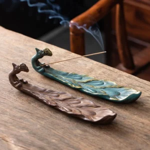 Peacock ceramic incense burner two color variants saddle brown and blue-green overhead view wooden table