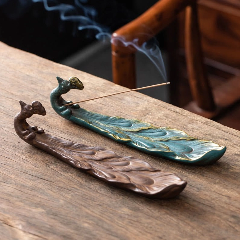 Peacock ceramic incense burner two color variants saddle brown and blue-green overhead view wooden table