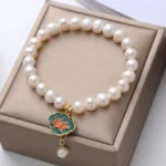 Pearl koi lotus Buddhist charm bracelet in elegant jewelry gift box, featuring enameled koi fish pendant and freshwater pearls, perfect spiritual gift