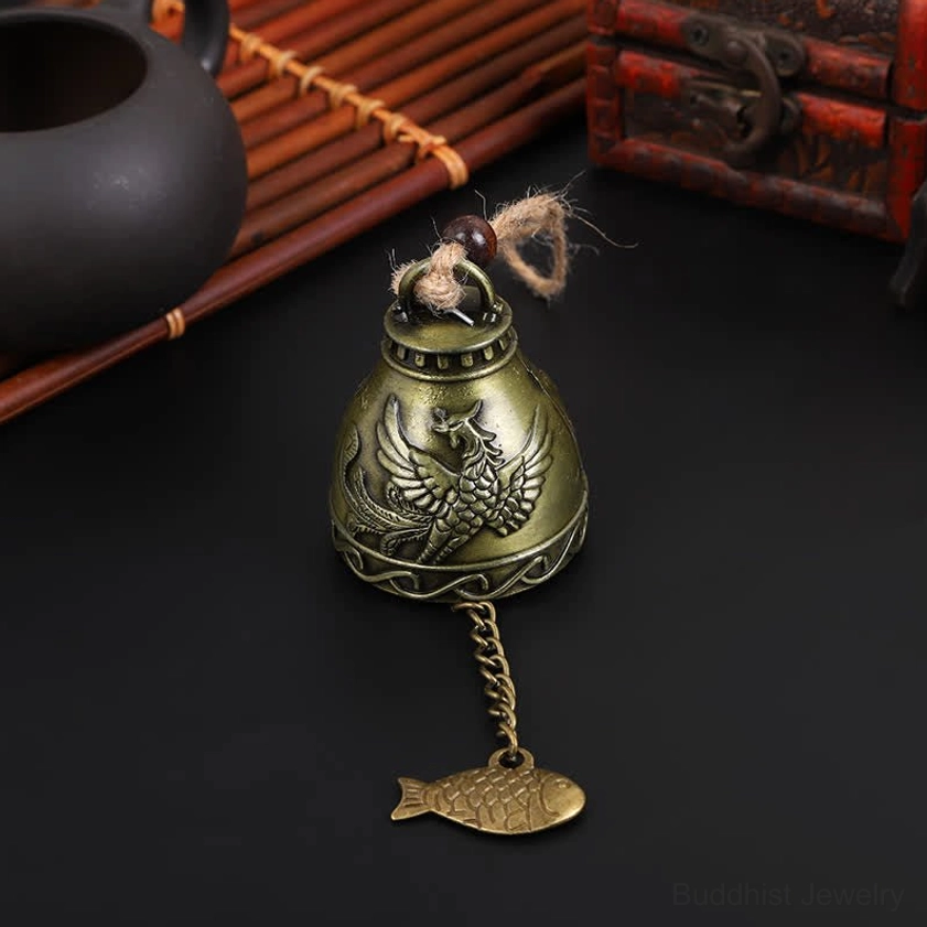 Phoenix wind chime bell with mythical bird carving representing transformation and rebirth