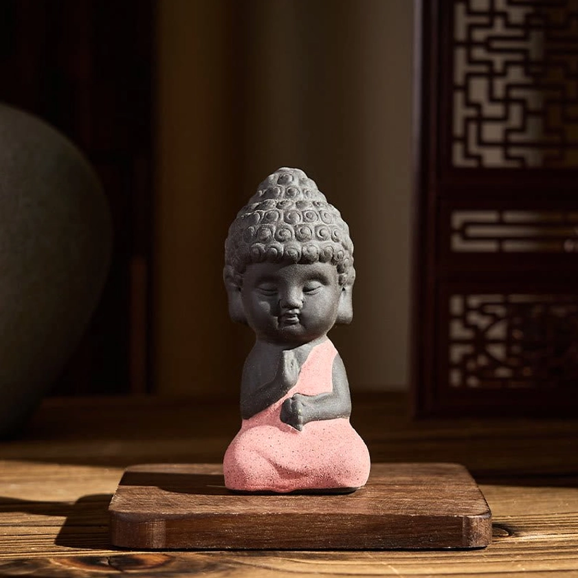 Pink robed Buddha statue seated in meditation pose, natural purple clay handcrafted spiritual figurine