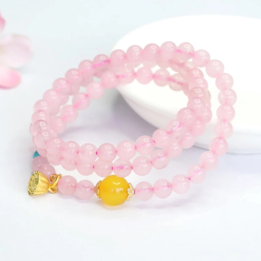 Buddhist healing bracelet with pink crystal beads and turquoise accents showing lotus charm detail