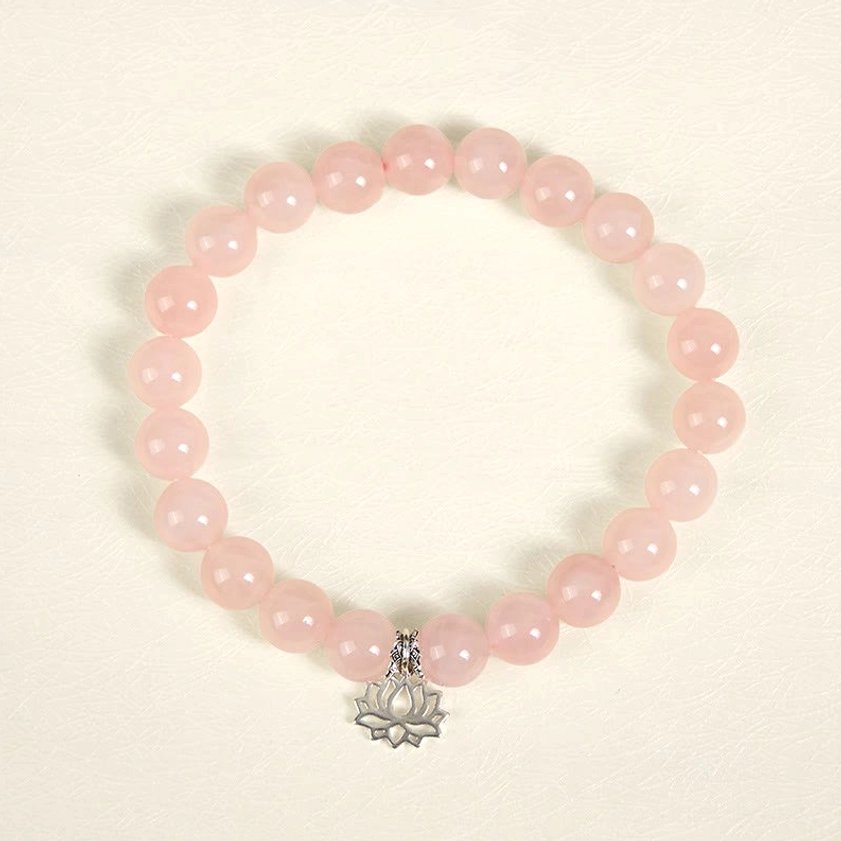 Pink crystal lotus charm bracelet laid flat showing silver lotus pendant detail
