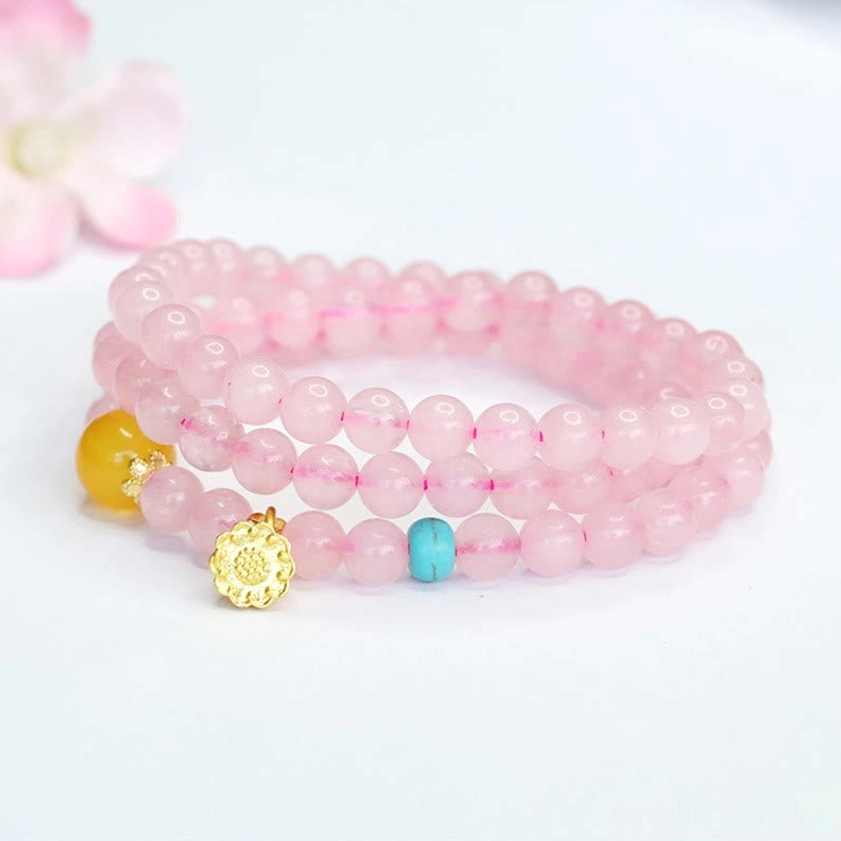 Pink crystal healing bracelet with gold lotus charm from side angle