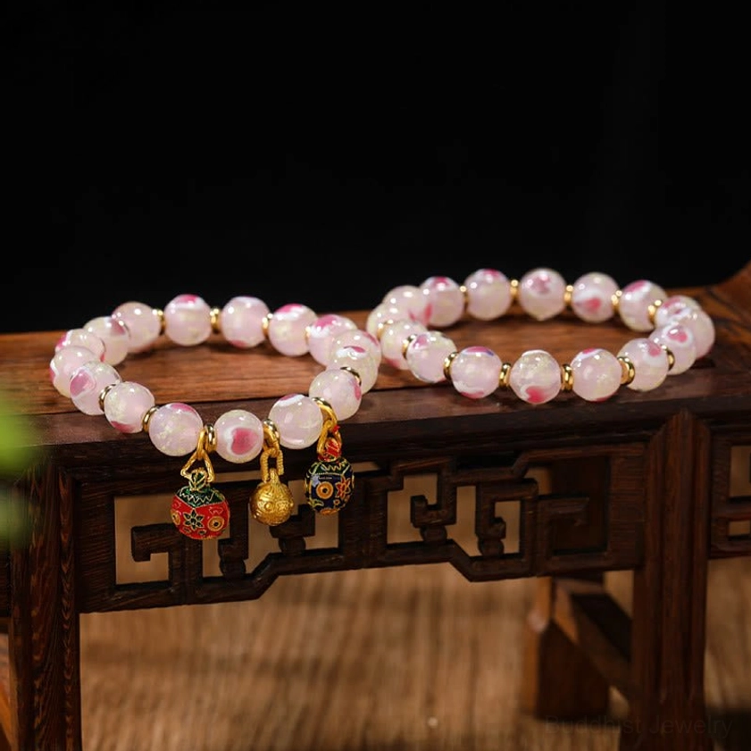 Luminous pink heart fluorescent liuli glass Buddhist blessing bracelet with gold swallowing beast family charm detail shot