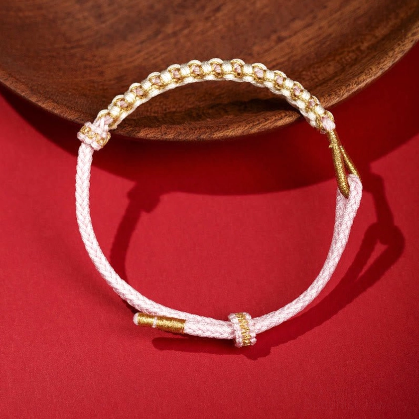 Pink handwoven peach blossom knot friendship bracelet with gold accents and adjustable fit
