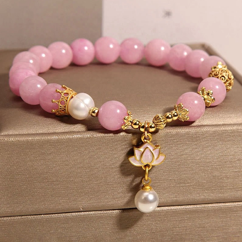 Pink Quartzite Lotus Pearl Bracelet - Flat lay showing detailed enameled lotus drop charm with pearl accent on leather jewelry box