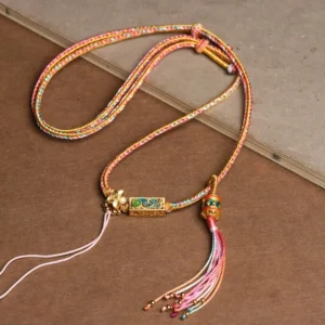 Pink and yellow braided copper string Buddhist necklace pendant with gradient tassel and gold enamel charm, handcrafted for prosperity
