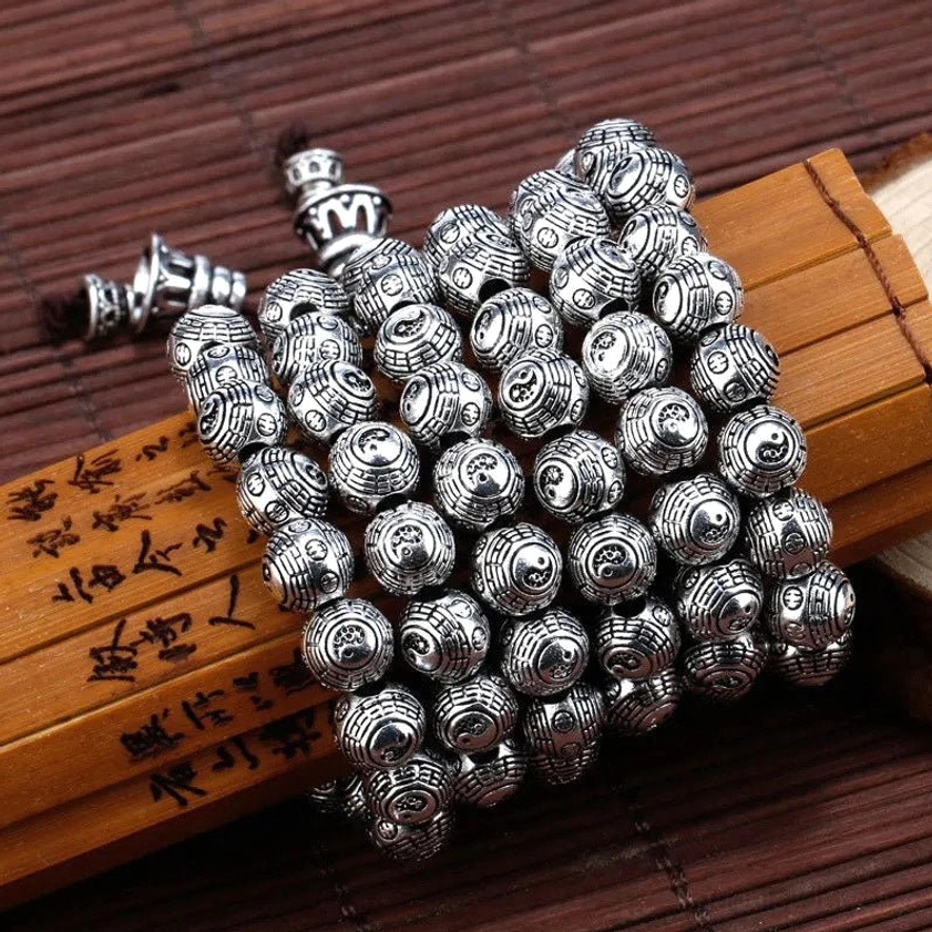 Buddhist Pixiu bracelet components and accessories, antique silver carved beads, guardian charms, metal clasps on bamboo mat with wooden vintage cards