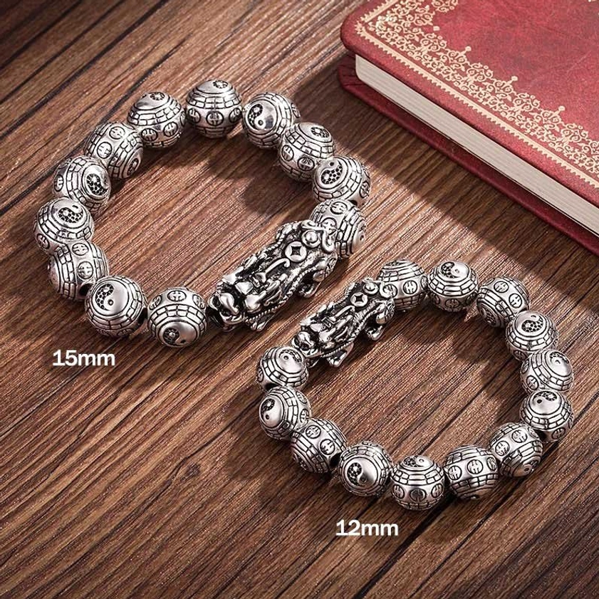 Two Buddhist Pixiu bracelets in different sizes (12mm and 15mm) displayed on wooden surface with antique silver carved beads and guardian charms