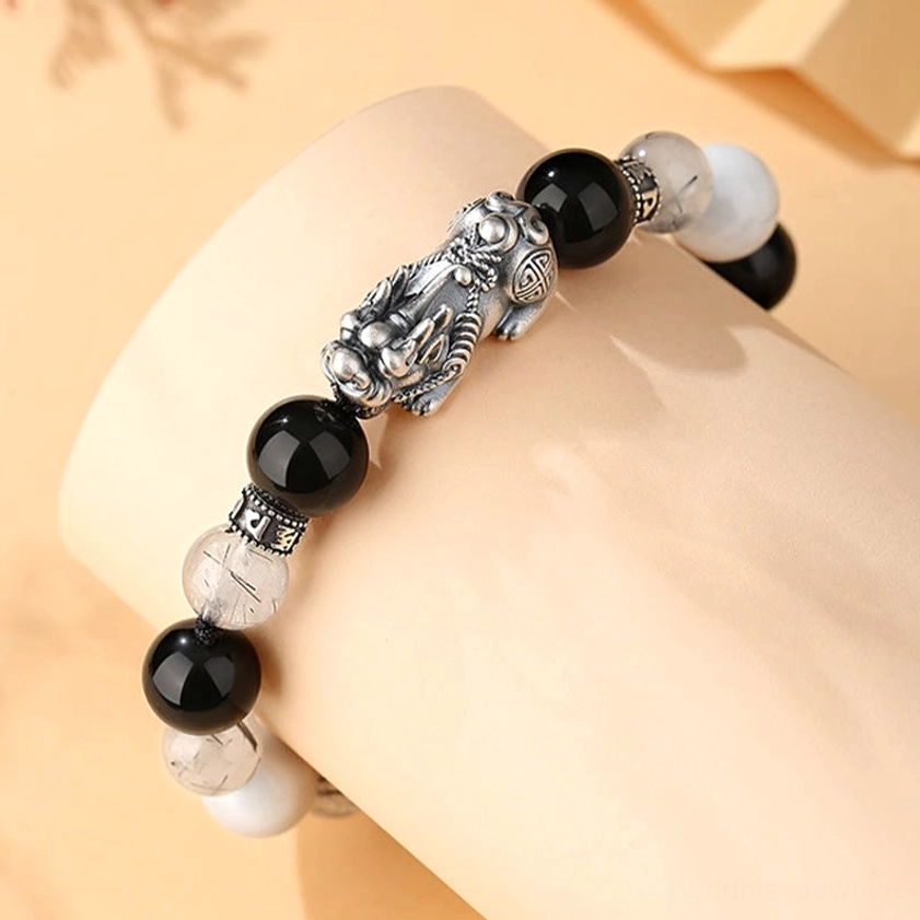 Pixiu prosperity bracelet worn on wrist, showing sterling silver charm and detailed bead textures on human forearm