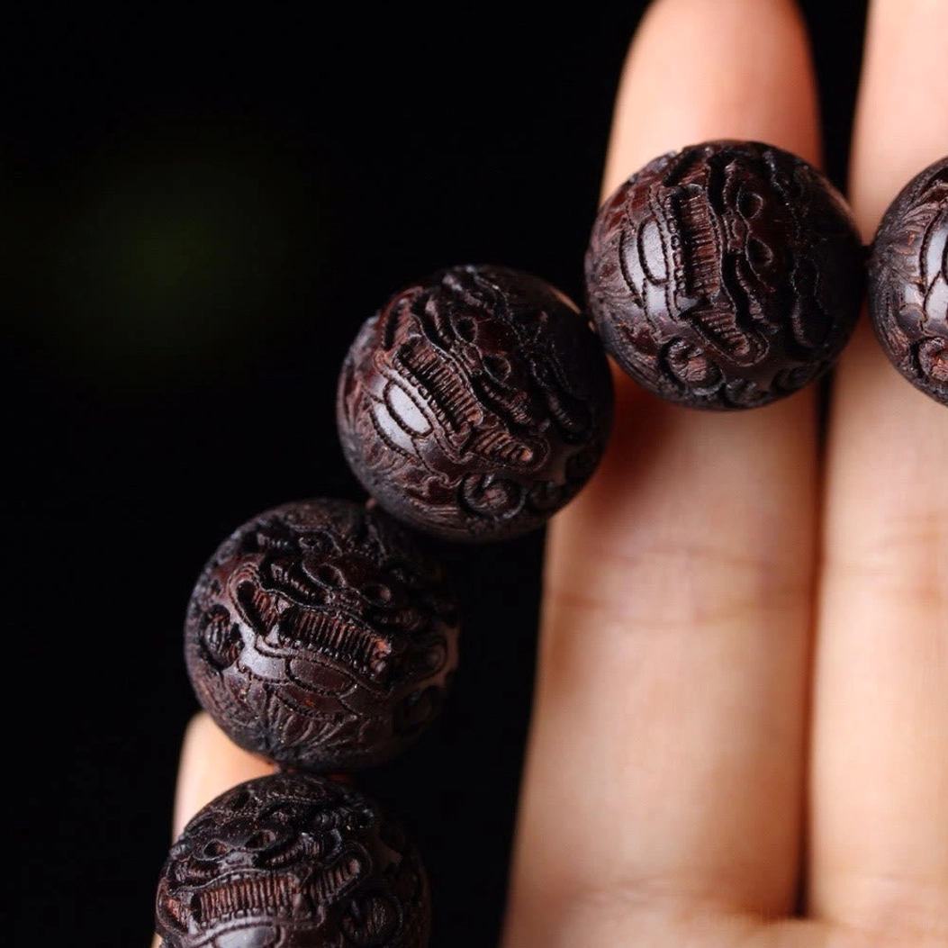 Close-up macro photography of Pixiu carved wooden beads showing intricate animal design details