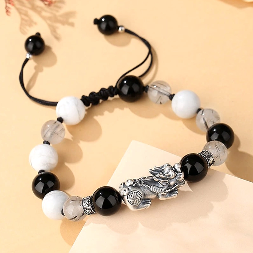 Close-up detail of sterling silver Pixiu charm and engraved Six True Words mantra on Buddhist prosperity bracelet