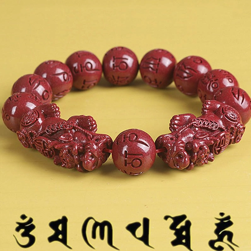 Double Pixiu cinnabar bracelet with om mani padme hum beads close-up detail on yellow background