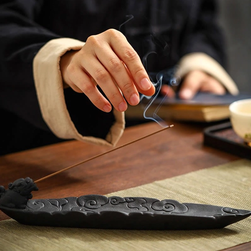 Pixiu cloud ceramic incense burner on traditional tea table with burning incense stick and tea ware