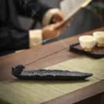 Pixiu auspicious clouds ceramic incense burner matte black with embossed design on tea table with rising smoke