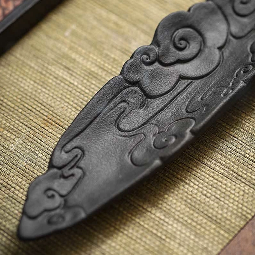 Cloud embossed ceramic incense burner overhead close-up on linen mat showing fine embossments