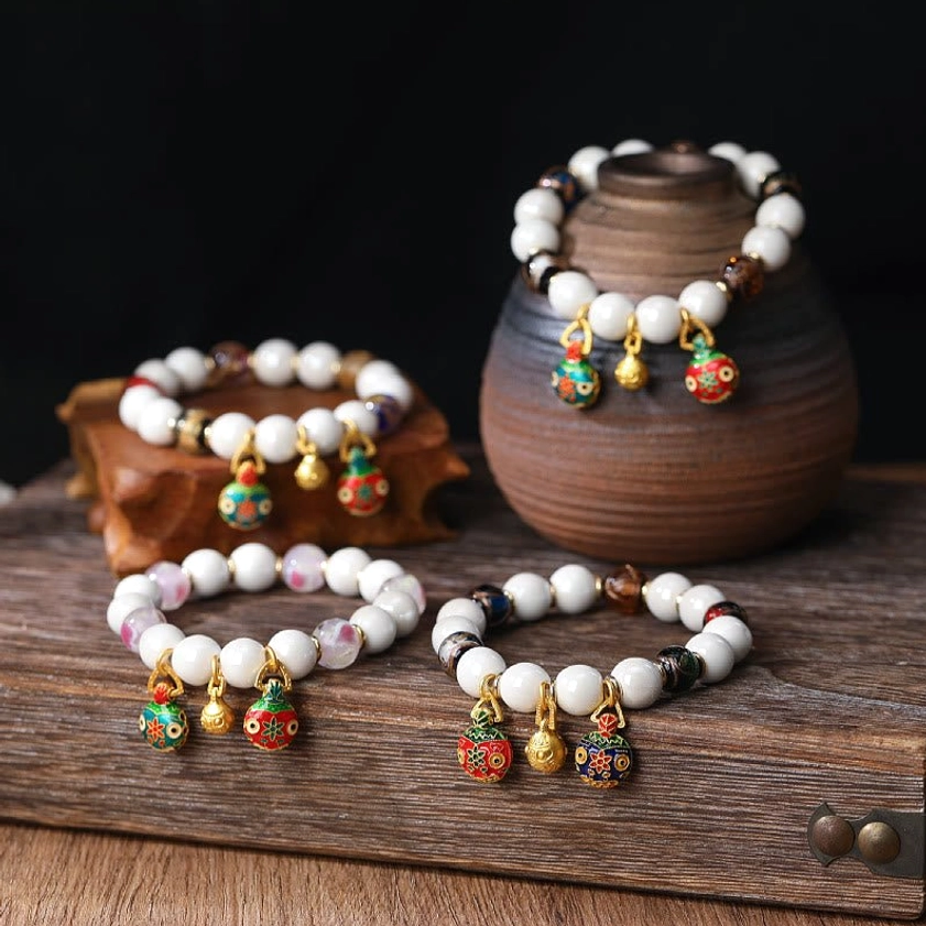 Loop colorful liuli glass bead bracelet with gradient colors and small enamel pendants on dark background