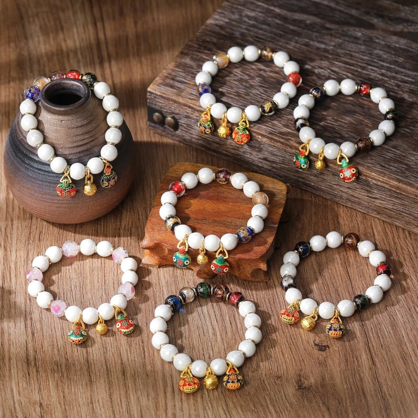 Colorful Buddhist lucky charm bracelet with mixed enamel pendants and gold-toned hardware details