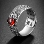 PiXiu Red Garnet Wealth Ring front oblique view - Buddhist symbol ring with carved silver band and natural red garnet gemstone