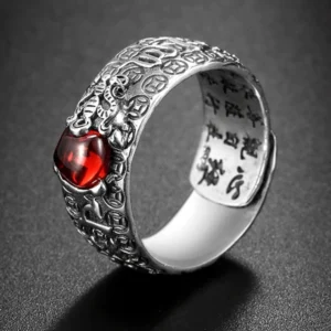 PiXiu Red Garnet Wealth Ring front oblique view - Buddhist symbol ring with carved silver band and natural red garnet gemstone