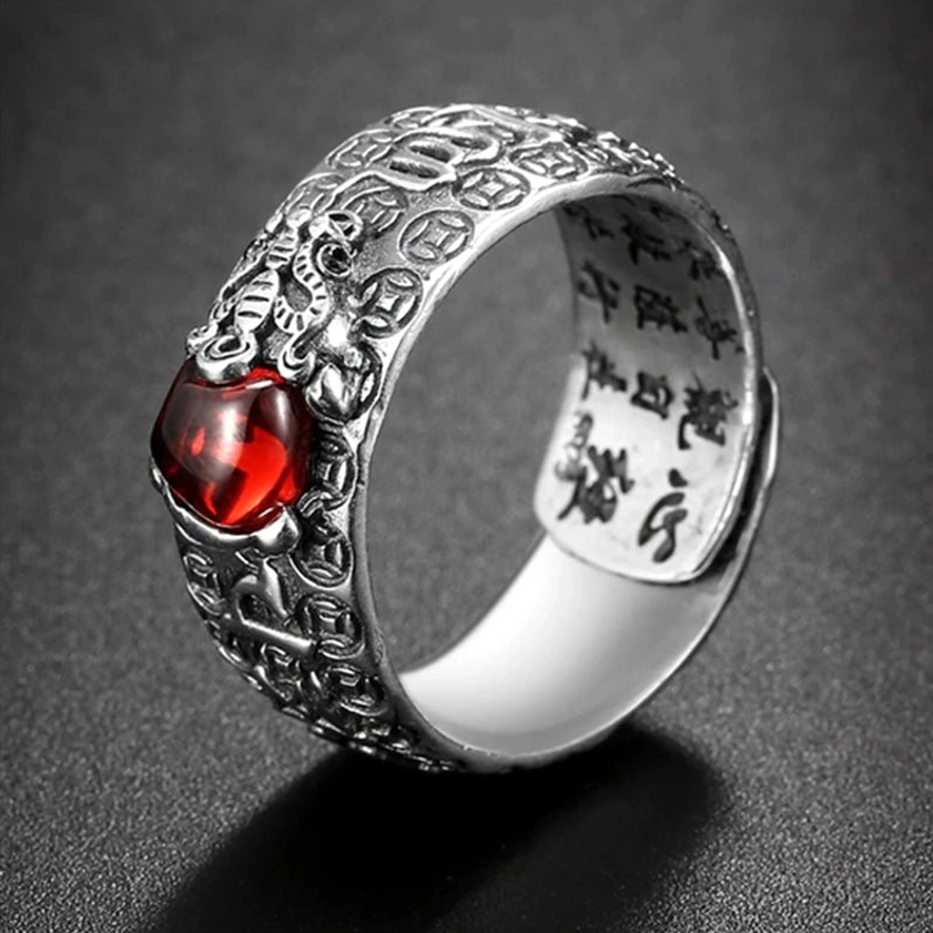 PiXiu Red Garnet Wealth Ring front oblique view - Buddhist symbol ring with carved silver band and natural red garnet gemstone