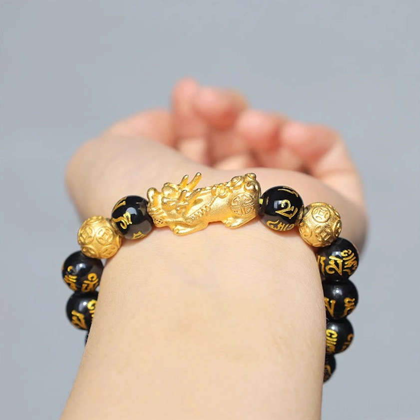 Golden Pixiu charm talisman detail on black obsidian wealth attraction bracelet for prosperity and fortune